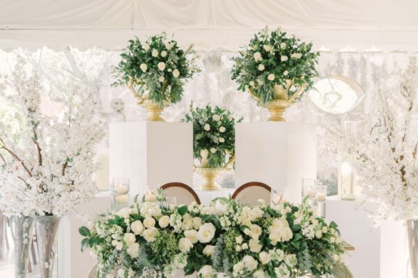 Elegant wedding sweetheart table with abundant white floral arrangements