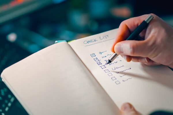 Hand writing a wedding day timeline checklist in a planning notebook