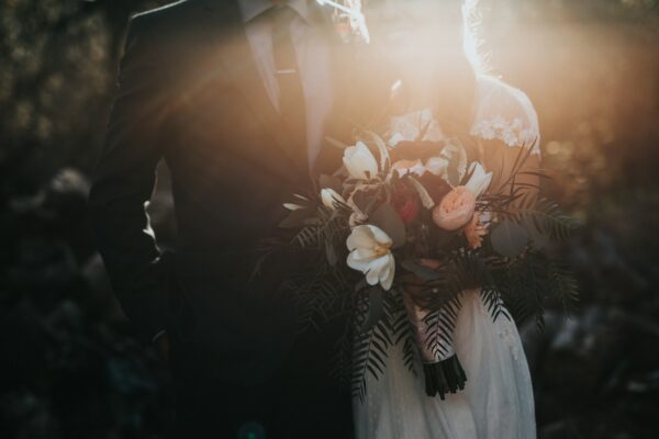 Outdoor wedding ceremony aisle lined with flowers and greenery